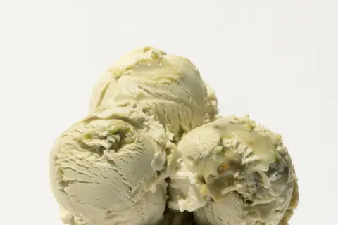 Tre kulor krämig pistage gelato med bitar av nötter.