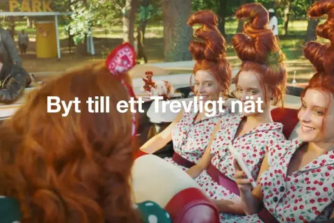Tre unga kvinnor med fantasifulla frisyrer i en bil. En reklamtext lyder "Byt till ett Trevligt nät".