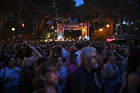 Multitud disfrutando de música al raso Zaragoza bajo un arco de agradecimiento.