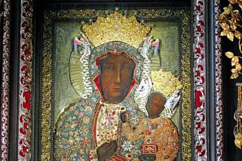 Obraz Matki Boskiej Częstochowskiej w bogatych szatach, z Dzieciątkiem Jezus. Wizerunek ten, znany z Jasnej Góry, można podziwiać w określone godziny odsłonięcia.