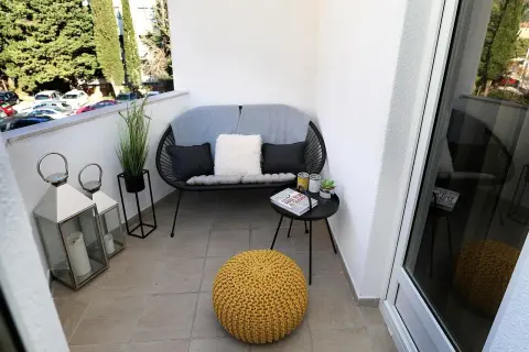 Przytulne balkony z wygodną kanapą, żółtą pufą i latarenkami. Idealne miejsce na relaks.