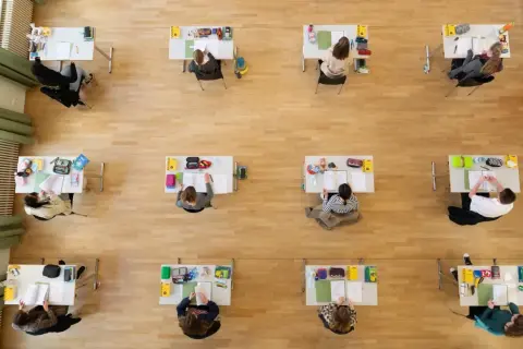 Schülerinnen und Schüler konzentriert bei Prüfungen, die an die Abiturtermine Niedersachsen 2026 erinnern.