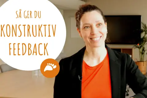 Kvinna ler och ger tips om hur man ger konstruktiv feedback.