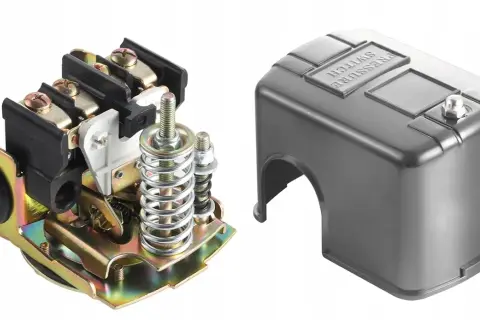 Mechanizm presostatu z elementami sprężynowymi i zaciskami, obok metalowa osłona z napisem "PRESSURE SWITCH".