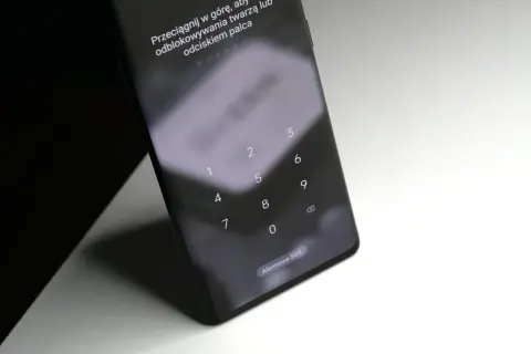 Ekran blokady telefonu z klawiaturą numeryczną i instrukcją "Przeciągnij w górę, aby użyć odblokowywania twarzą lub odciskiem palca". Jak odblokować telefon bez utraty danych?