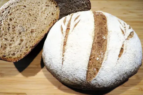 Pane rustico con farina 00, crosta dorata e mollica alveolata, pronto per essere gustato.