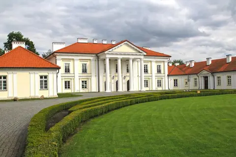 Pałac w Siedlcach, jeden z pięknych zabytków, otoczony zielonym ogrodem i ozdobnymi żywopłotami.