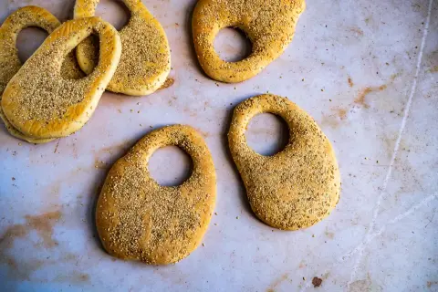 Plusieurs kaaks libanais dorés, saupoudrés de graines de sésame, sont disposés sur une surface claire.