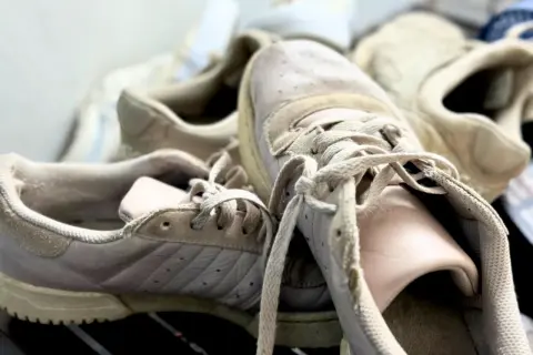 Des baskets beiges un peu usées, prêtes pour un bon nettoyage.