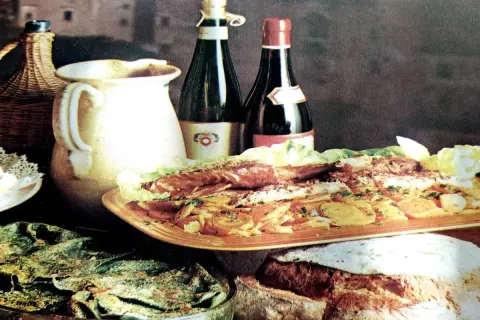 Un banchetto con pesce, verdure e pane fresco, accompagnato da vino e brocca. Sapori autentici del **chilometro zero Rodi Garganico**.