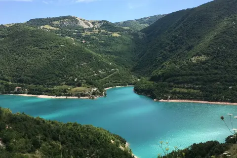 Un lago turchese incastonato tra le verdi marche montagna. Un paesaggio mozzafiato che invita alla serenità.