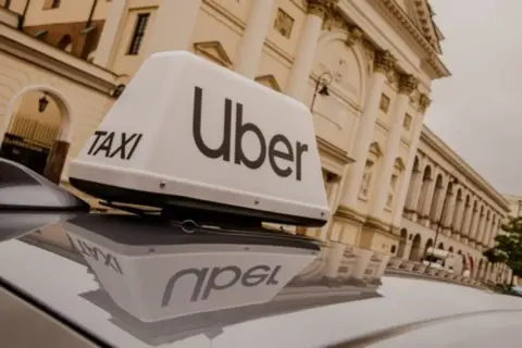 Zastanawiasz się, ile kosztuje licencja taxi? Na dachu samochodu Uber widać napis "TAXI".