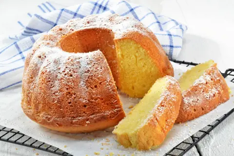 En saftig sockerkaka med sirap istället för socker, pudrad med florsocker. Två skivor ligger bredvid den hela kakan.