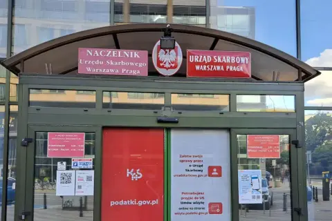 Jak określić właściwy urząd skarbowy? Na budynku widnieje napis "Urząd Skarbowy Warszawa Praga" oraz informacje o godzinach otwarcia.