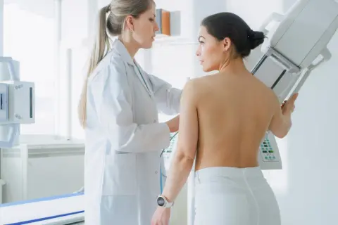 Lekarka wykonuje mammografię pacjentce. Wynik BIRADS 3 oznacza, że zmiany są łagodne, ale wymagają kontroli.