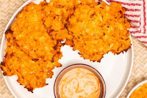 Knusprige Kartoffelpuffer, im Ofen gebacken, serviert mit einer cremigen Dip-Sauce. Perfekt für einen herzhaften Snack.