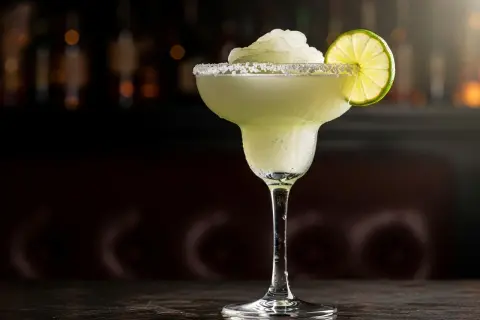 En frostig frozen margarita med saltkant och limeklyfta, perfekt för en varm kväll.