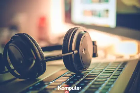 Słuchawki na klawiaturze laptopa, gotowe do zanurzenia się w muzyce na komputerze.