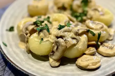 Pyszne kluski śląskie w kremowym sosie grzybowym. Idealny przepis na to, jak zrobić sos do klusek śląskich, który zachwyci każdego.