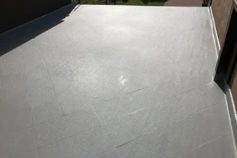 Szara, błyszcząca powierzchnia dachu pokryta polimocznikiem. Sprawdź atrakcyjną polimocznik cena za m2.