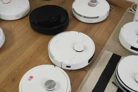 Różne roboty sprzątające na drewnianej podłodze, przygotowane do rankingu.