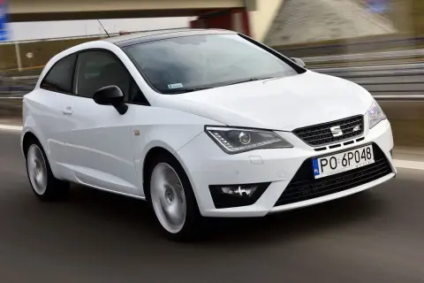 Biały Seat Ibiza 1.4 benzyna pędzi po drodze, z czarnym dachem i felgami.
