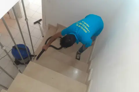 Un trabajador aspira escaleras para quitar polvo de obra.