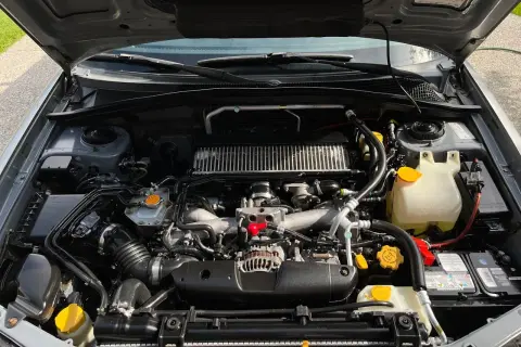 Silnik Subaru z widocznym zbiorniczkiem płynu chłodniczego. Sprawdzanie, ile mieści się płynu w chłodnicy, jest kluczowe dla jej prawidłowego działania.