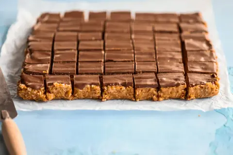 En hel plåt med chokladöverdragna bitar, redo att avnjutas. Ett perfekt snickerskaka recept för fikat.
