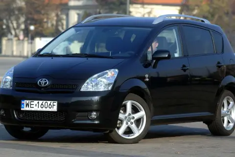 Czarny Toyota Verso z polskimi tablicami WE 1606F zaparkowany na ulicy.