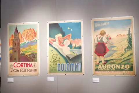 Tre manifesti vintage di una collezione salce promuovono le Dolomiti: Cortina, una donna rilassata e una bambina con fiori ad Auronzo.