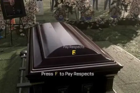 Na cmentarzu trumna, obok zdjęcie zmarłego. Na trumnie napis "Press F to Pay Respects".