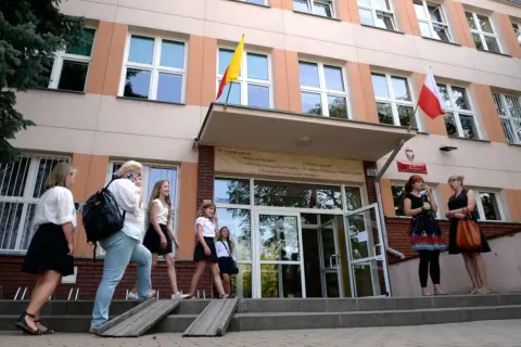 Uczniowie wchodzą do szkoły, przypominając czasy, kiedy powstały gimnazja w Polsce.