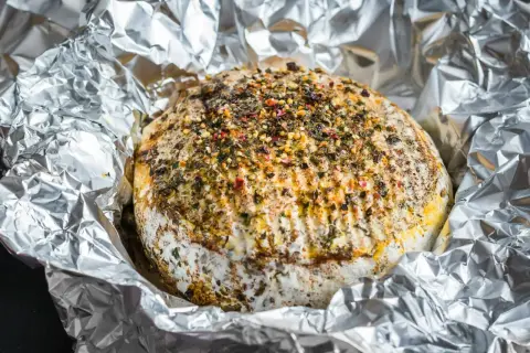 Pyszny camembert z grilla, otulony folią aluminiową, posypany ziołami i przyprawami. Idealny na letnie wieczory.