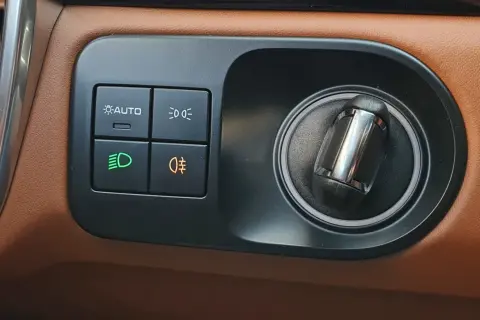 Panel sterowania w Oplu Astra H. Przyciski do świateł: AUTO, mijania, przeciwmgielne (tylne pomarańczowe).