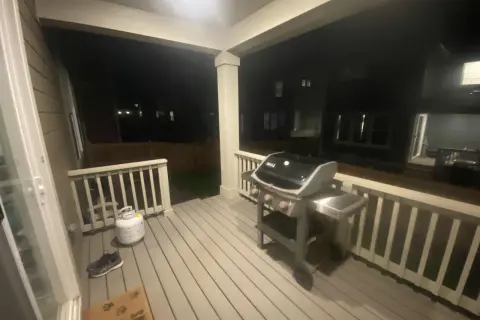 En gasolgrill under taket på altanen, redo för sommarens grillkvällar.