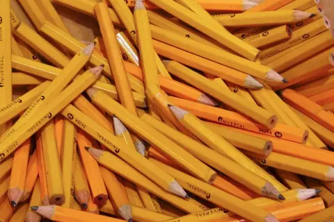 A pile of yellow pencils, a classic choice for a reason. Why are pencils yellow? It's a tradition dating back to the 1800s.