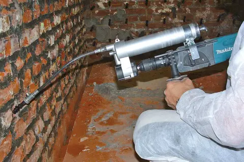Mauerwerk Injektion selber machen: Gerät zur Rissverpressung an einer Ziegelwand.