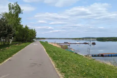 Ścieżka rowerowa wzdłuż jeziora, gdzie cumują żaglówki. Pogoria 4 zaprasza do aktywnego wypoczynku.