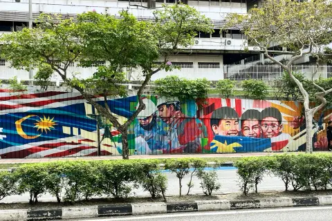 Kolorowy mural z flagą Malezji i uśmiechniętymi dziećmi. Wiza do Malezji może być pierwszym krokiem do zobaczenia tego piękna.