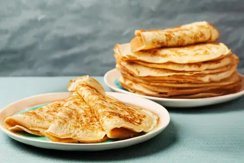 Gestapelte Pfannkuchen auf Tellern, bereit für ein köstliches Pfannkuchen Rezept.