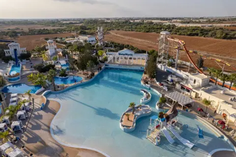 Aerial view of a water park with slides, pools, and a wave pool.