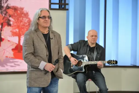 Mężczyzna z mikrofonem i długimi włosami, obok gitarzysty. Może to być scena z wykonania "perfect kołysanka dla nieznajomej lyrics".