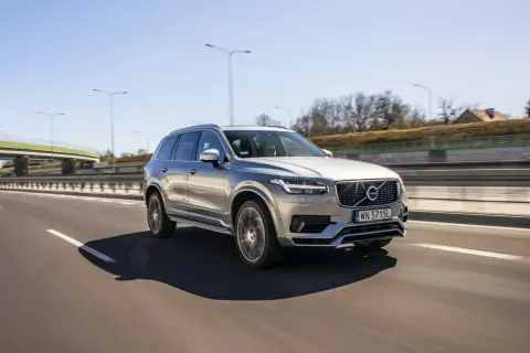 Srebrne Volvo XC90 jedzie autostradą. Kierowca zastanawia się nad jego spalaniem.