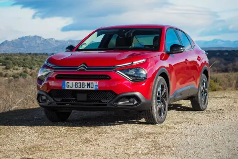 Czerwony Citroën C4X na tle górskiego krajobrazu.