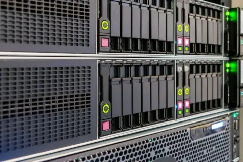 Server-Rack mit mehreren Festplattenschächten, bereit für ein RAID 5 mit 4 Festplatten. Grüne und rote LEDs zeigen den Status an.