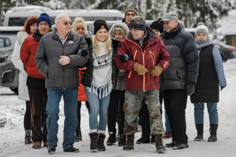 Grupa seniorów i młodszych osób spaceruje w zimowej scenerii. Czy to zapowiedź, kiedy jest powtórka Sanatorium Miłości?