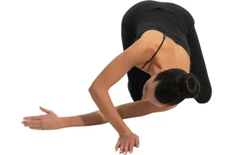 Donna in posa yoga, con le scapole alate che si aprono in un movimento fluido.