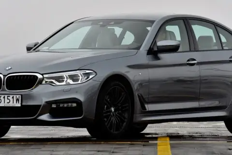 Szary sedan BMW Serii 5, z czarnymi felgami i tablicą rejestracyjną WY 6151W. Poznaj jego bmw 5 dane techniczne.