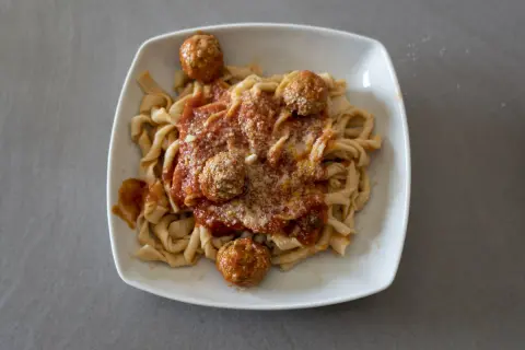 Sagne ncannulate con polpette al sugo, un piatto ricco e saporito, pronto per essere gustato.